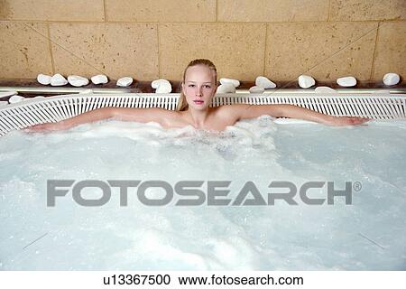 Stock Image - Young woman in jacuzzi at a spa. Fotosearch