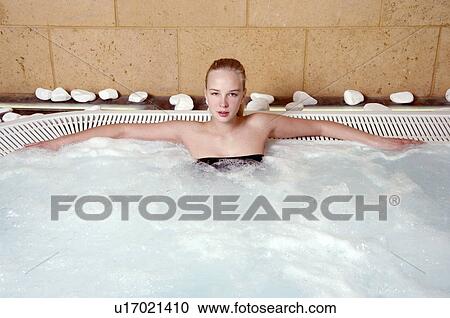 Stock Image - Young woman in jacuzzi at a spa. Fotosearch