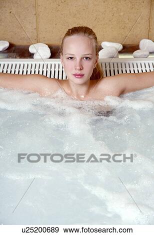Stock Photo - Young woman in jacuzzi at a spa. Fotosearch