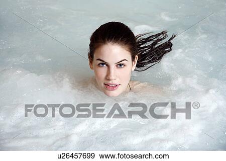 Stock Photo - Young woman in jacuzzi at a spa. Fotosearch