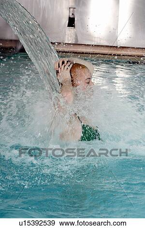 Young woman standing under water spray in spa pool View Large Photo Image Stock Photo - Young woman standing under water spray in spa pool. Fotosearch