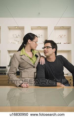 Stock Image - Couple posing with eyeglasses in store. Fotosearch