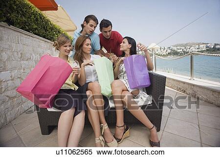 Stock Photography - Group of friends with shopping bags posing. Fotosearch