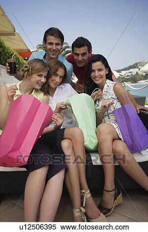 Stock Photography - Group of friends with shopping bags posing. Fotosearch