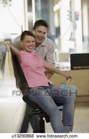 Happy couple posing with shopping bags in a sunglasses store View Large Photo Image Stock Photo - Happy couple posing with shopping bags in a sunglasses store. Fotosearch