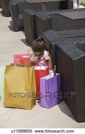Stock Photography - Three women with shopping bags toasting. Fotosearch