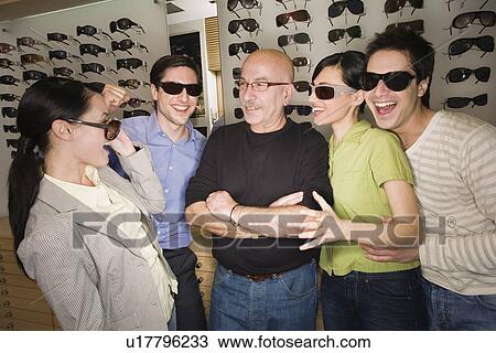 Two couples posing with sunglasses in store with shopkeeper View Large Photo Image Stock Image - Two couples posing with sunglasses in store with shopkeeper. Fotosearch