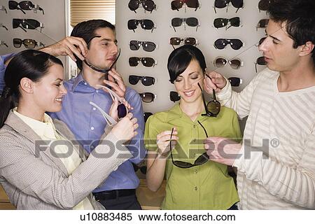 Two couples shopping for sunglasses in store View Large Photo Image Stock Photography - Two couples shopping for sunglasses in store. Fotosearch
