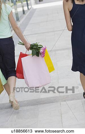 Two women walking with shopping bags View Large Photo Image Stock Image - Two women walking with shopping bags. Fotosearch