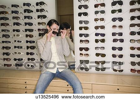 Woman posing in front of sunglasses display View Large Photo Image Stock Photograph - Woman posing in front of sunglasses display. Fotosearch