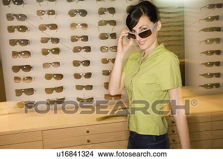 Woman shopping in sunglasses store View Large Photo Image Picture - Woman shopping in sunglasses store. Fotosearch