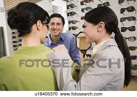 Woman trying on sunglasses in store View Large Photo Image Stock Image - Woman trying on sunglasses in store. Fotosearch