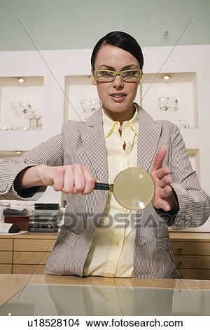 Picture - Woman with magnifying glass in store. Fotosearch