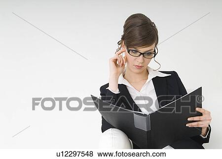 Businesswoman looking at file View Large Photo Image Stock Photo - Businesswoman looking at file. Fotosearch