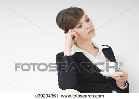 Stock Image - Portrait of young woman holding a cup. Fotosearch