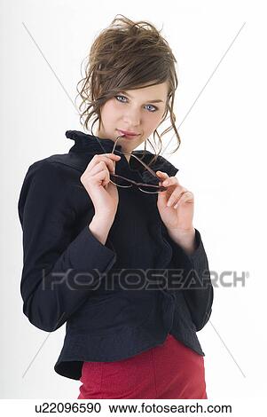 Stock Image - Portrait of young woman holding sunglasses. Fotosearch
