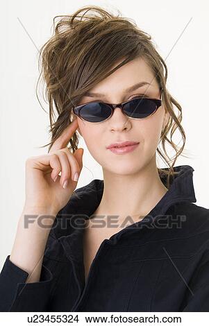 Portrait of young woman wearing sunglasses View Large Photo Image Picture - Portrait of young woman wearing sunglasses. Fotosearch