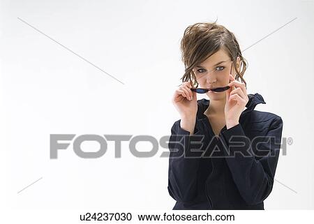 Portrait of young woman wearing sunglasses View Large Photo Image Stock Image - Portrait of young woman wearing sunglasses. Fotosearch