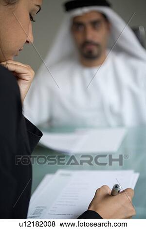 Stock Photo - signing, business, woman, businessmen, businessman, Arabic. Fotosearch
