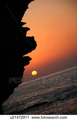 Stock Image - sunset, sunrise, beach, rocks. Fotosearch