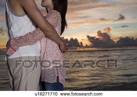Young couple embracing on beach, Saipan, USA View Large Photo Image Stock Image - Young couple embracing on beach, Saipan, USA . Fotosearch