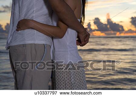 Young couple embracing on beach, Saipan, USA View Large Photo Image Stock Photo - Young couple embracing on beach, Saipan, USA . Fotosearch
