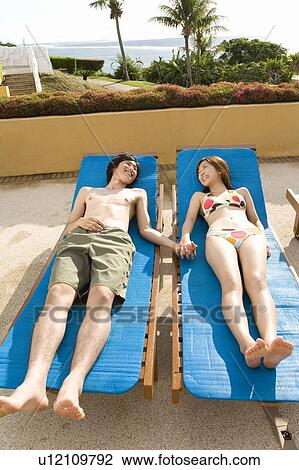 Young couple lying on beach chairs, Saipan View Large Photo Image Stock Image - Young couple lying on beach chairs, Saipan. Fotosearch