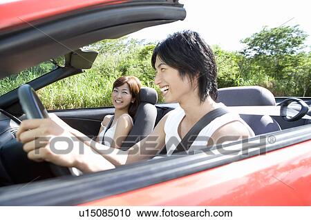 Young couple smiling in the car, man holding steering wheel, Saipan, USA View Large Photo Image Stock Image - Young couple smiling in the car, man holding steering wheel, Saipan, USA. Fotosearch