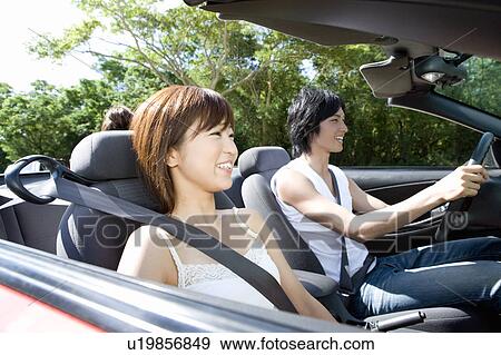 Young couple smiling in the car, man holding steering wheel, Saipan, USA View Large Photo Image Stock Photo - Young couple smiling in the car, man holding steering wheel, Saipan, USA. Fotosearch
