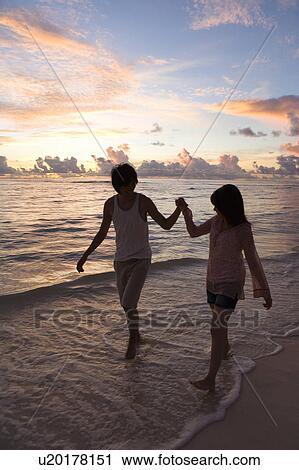 Young couple walking on beach, hand in hand, Saipan, USA View Large Photo Image Stock Image - Young couple walking on beach, hand in hand, Saipan, USA . Fotosearch