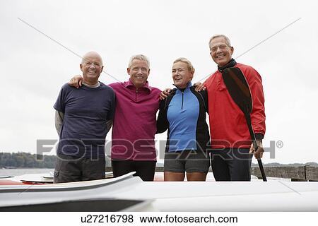 Stock Photo - Four kayakers standing side by side. Fotosearch