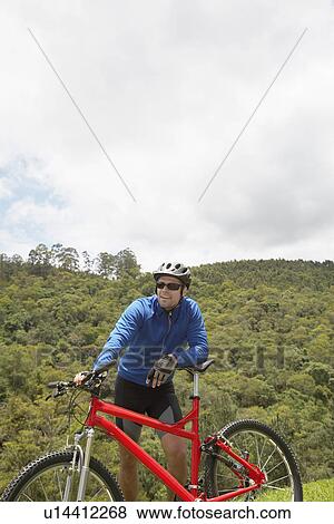 Male cyclist leaning on mountain bike View Large Photo Image Stock Photo - Male cyclist leaning on mountain bike. Fotosearch
