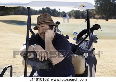 Man talking on phone in golf cart View Large Photo Image Stock Image - Man talking on phone in golf cart. Fotosearch