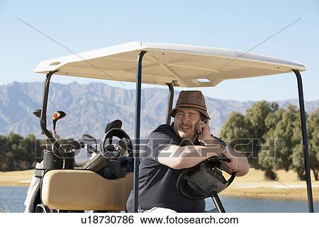 Man talking on phone in golf cart View Large Photo Image Stock Photograph - Man talking on phone in golf cart. Fotosearch