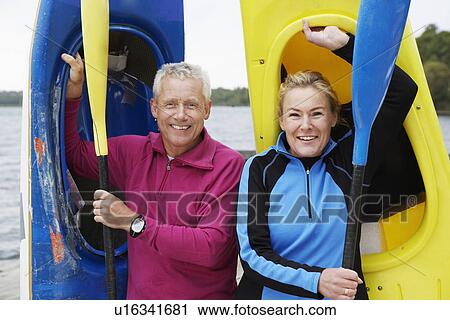 Mature man and woman carrying kayaks View Large Photo Image Stock Image - Mature man and woman carrying kayaks. Fotosearch