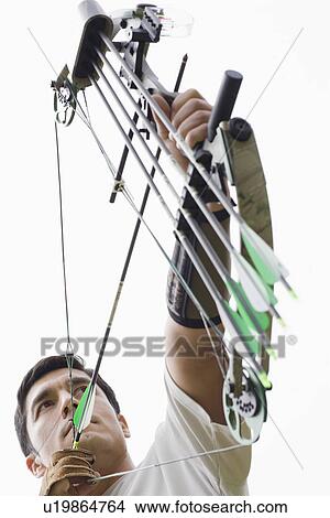 Mid adult man arrow shooting (low angle view) View Large Photo Image Picture - Mid adult man arrow shooting (low angle view). Fotosearch