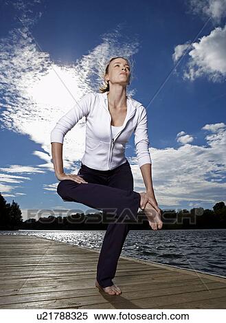 Mid Adult Woman Stretching on Jetty View Large Photo Image Stock Photography - Mid Adult Woman Stretching on Jetty. Fotosearch
