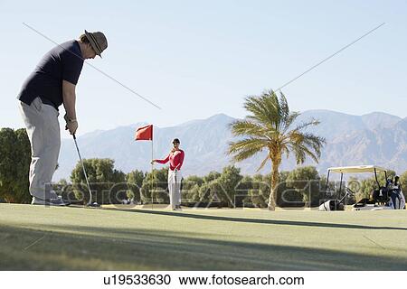 Two people playing golf at golf course View Large Photo Image Stock Image - Two people playing golf at golf course. Fotosearch