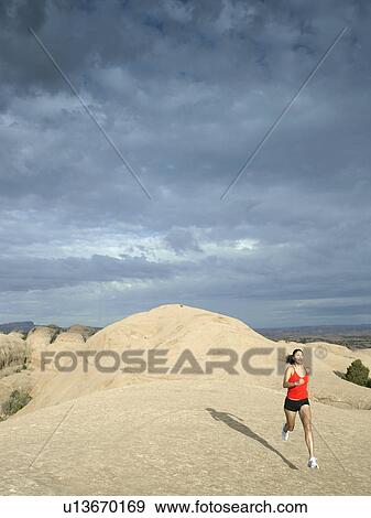 Stock Photo - Woman jogging in desert. Fotosearch