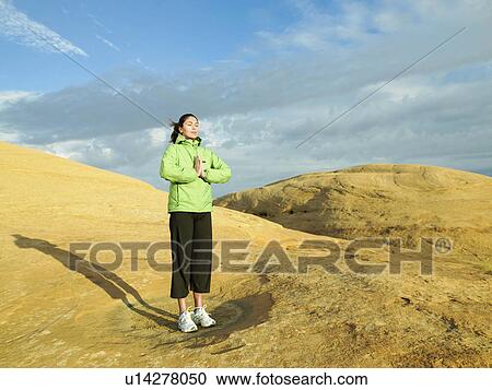 Woman meditating on rocky hill View Large Photo Image Stock Image - Woman meditating on rocky hill. Fotosearch