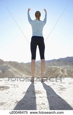 Young woman doing yoga in desert (rear view, low angle view) View Large Photo Image Stock Photography - Young woman doing yoga in desert (rear view, low angle view). Fotosearch