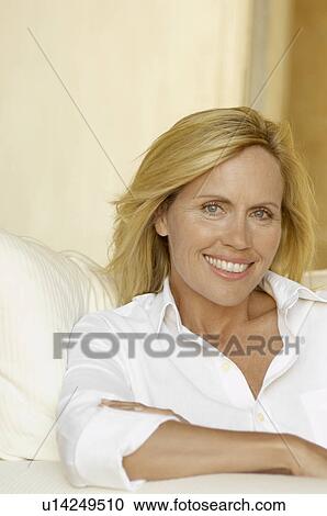 Mature woman in white shirt on armchair View Large Photo Image Stock Image - Mature woman in white shirt on armchair. Fotosearch