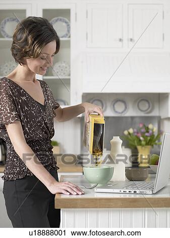 Mid adult woman pouring breakfast cereals View Large Photo Image Stock Image - Mid adult woman pouring breakfast cereals. Fotosearch