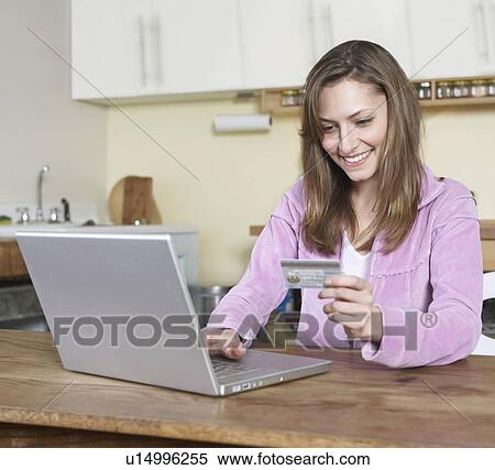 Stock Photography - Mid-Adult Woman Shopping Online. Fotosearch