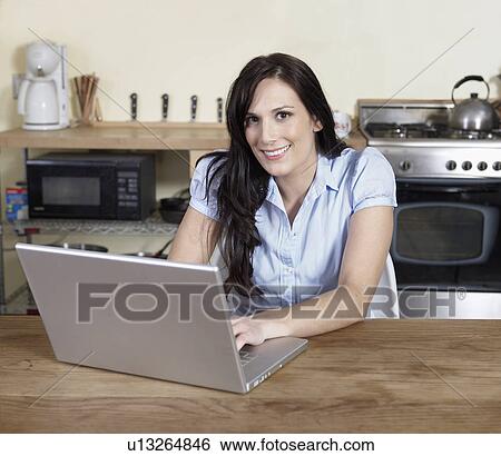 Mid-Adult Woman Using Laptop in Kitchen View Large Photo Image Stock Photograph - Mid-Adult Woman Using Laptop in Kitchen. Fotosearch
