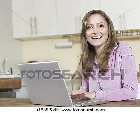 Stock Image - Mid-Adult Woman Using Laptop. Fotosearch