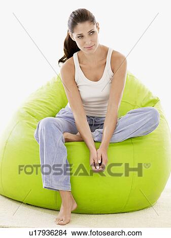 Young woman sitting on beanbag (portrait) View Large Photo Image Picture - Young woman sitting on beanbag (portrait). Fotosearch