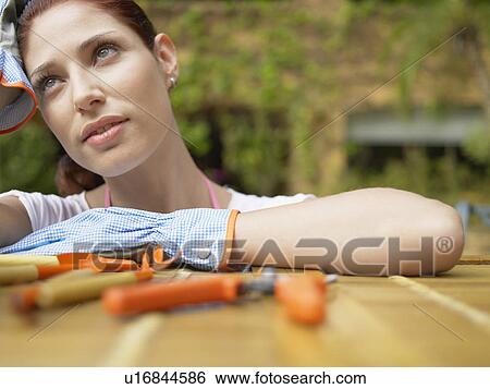 Stock Photograph - Gardener resting head on hand (portrait). Fotosearch