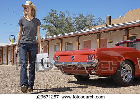 Young woman arriving at motel View Large Photo Image Stock Photo - Young woman arriving at motel. Fotosearch