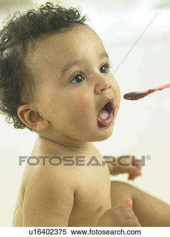 Baby being fed from a spoon View Large Photo Image Stock Photography - Baby being fed from a spoon. Fotosearch